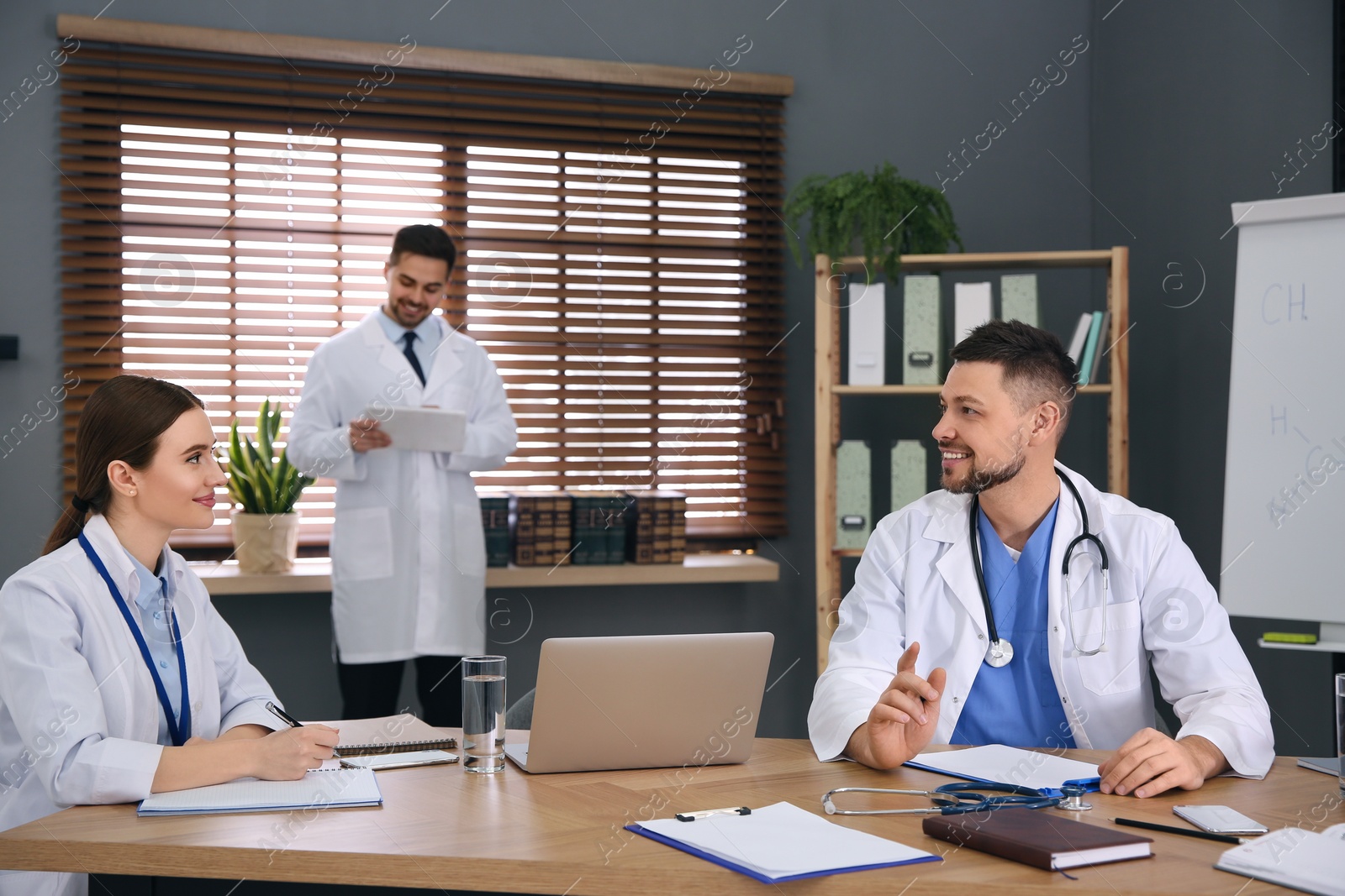 Photo of Team of professional doctors having meeting in office