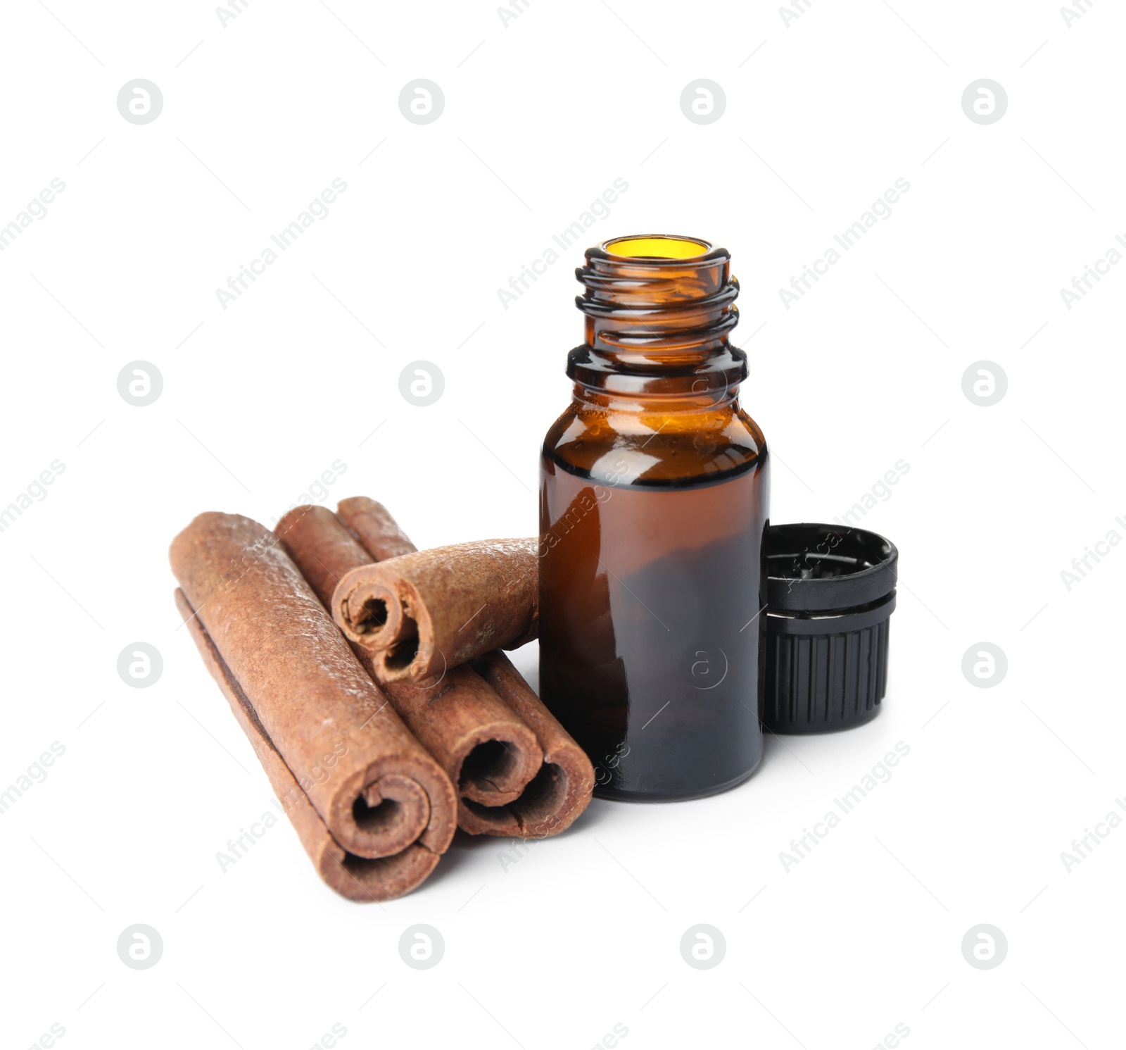 Photo of Bottle of essential oil and cinnamon sticks on white background