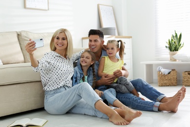 Photo of Happy family taking selfie on floor at home