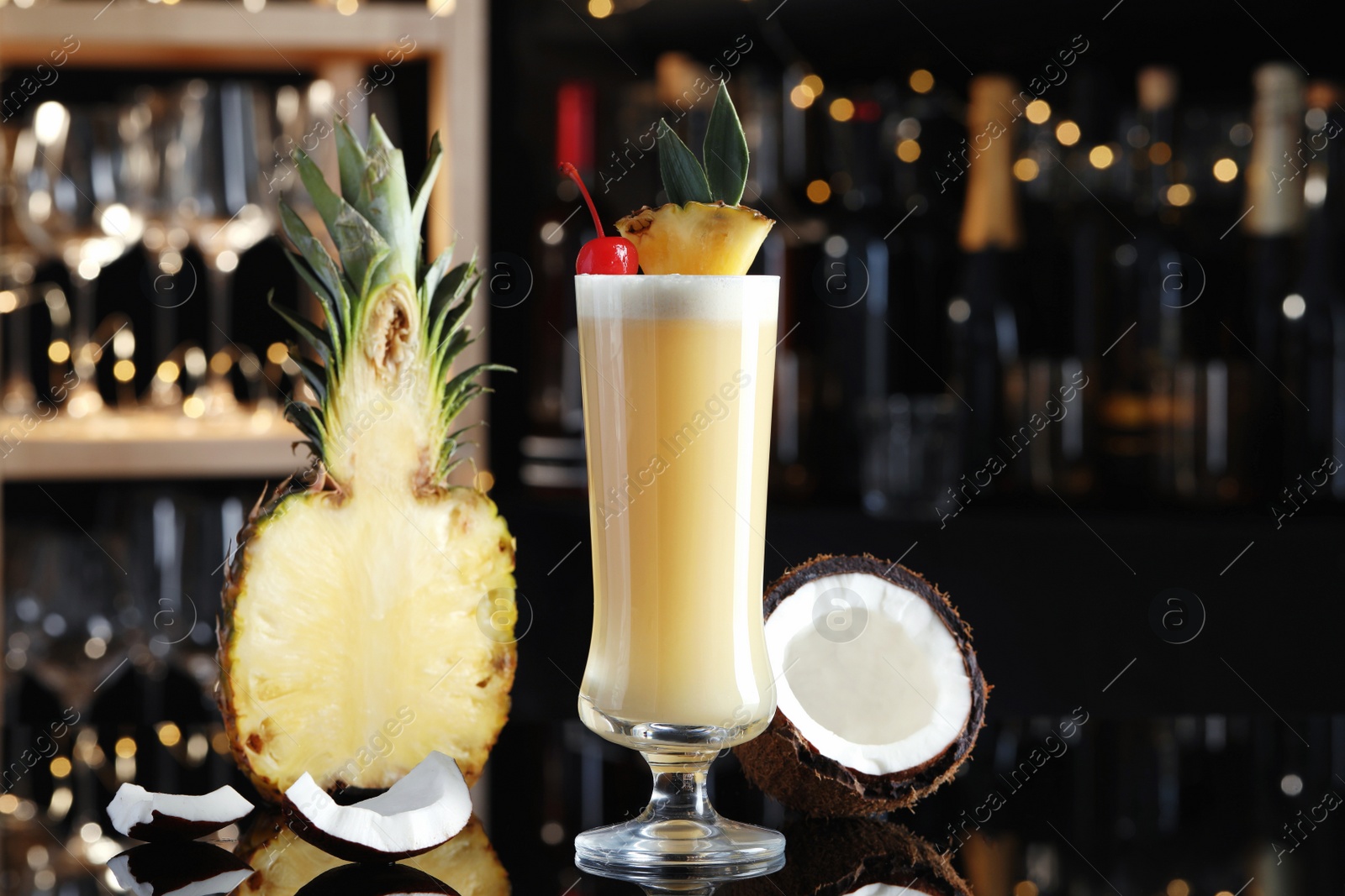 Photo of Tasty Pina Colada cocktail and ingredients on bar countertop