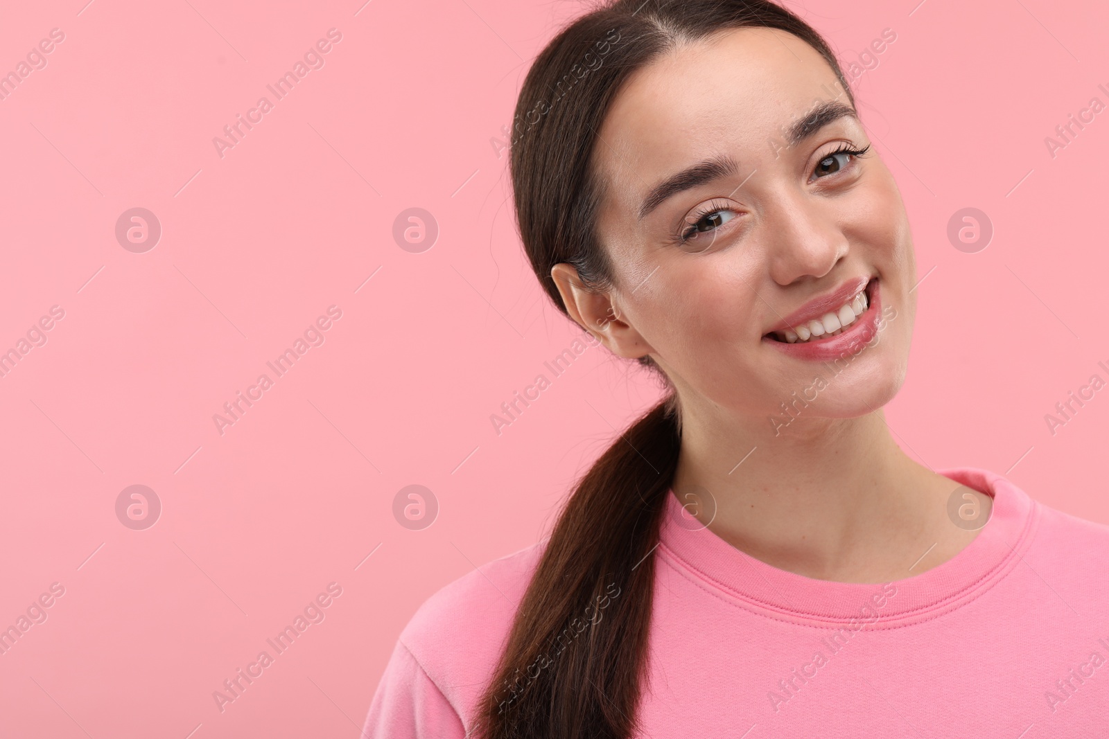 Photo of Beautiful woman with clean teeth smiling on pink background, space for text