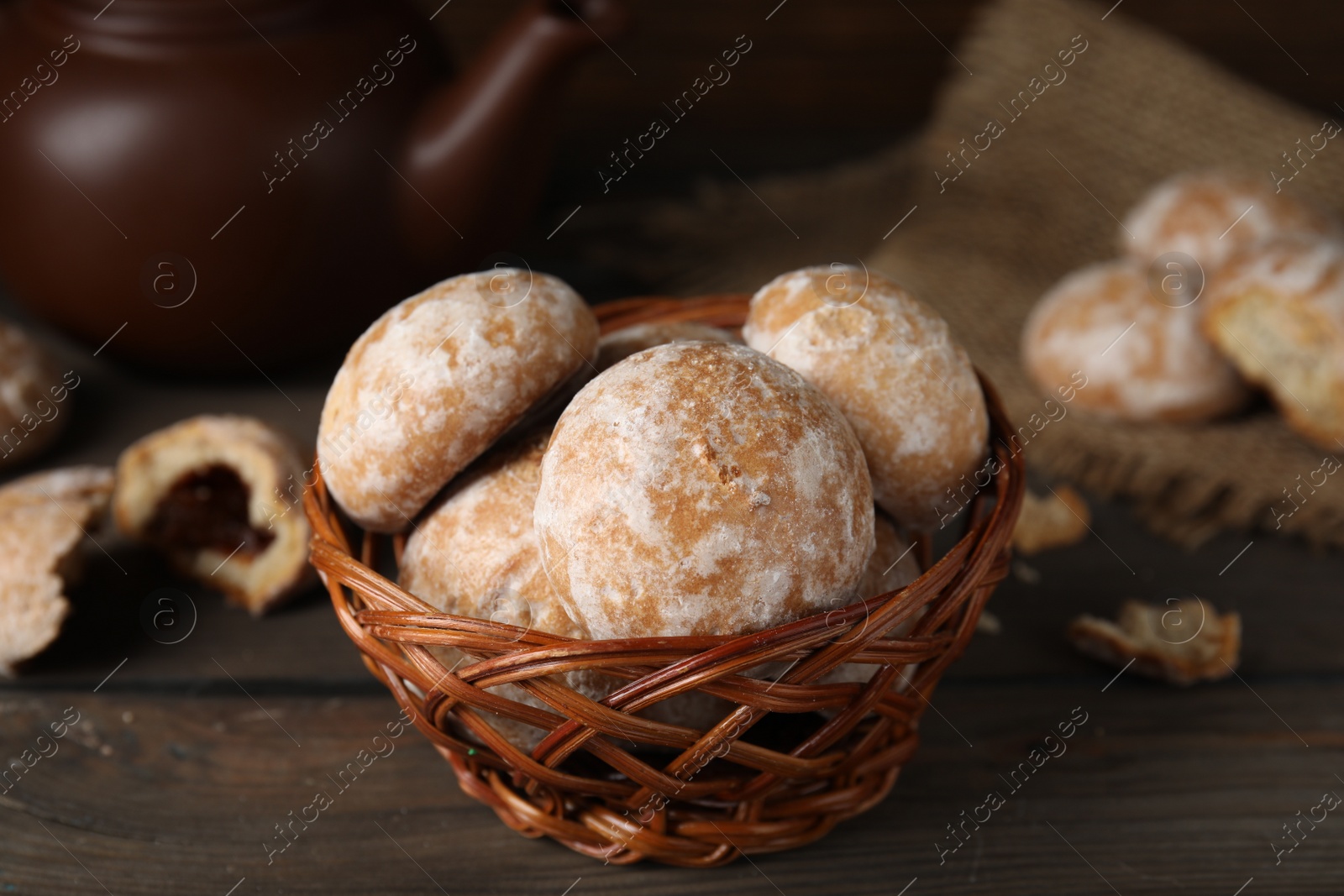 Photo of Tasty homemade gingerbread cookies in wicker basket on wooden table