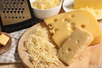 Photo of Grated, cut cheese and grater on table, closeup