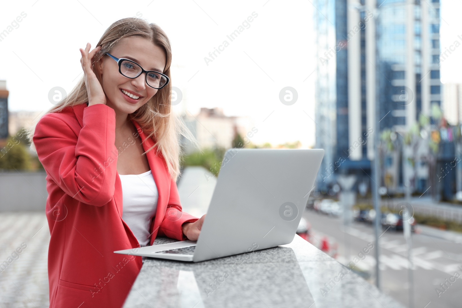 Photo of Beautiful businesswoman with glasses using laptop in city