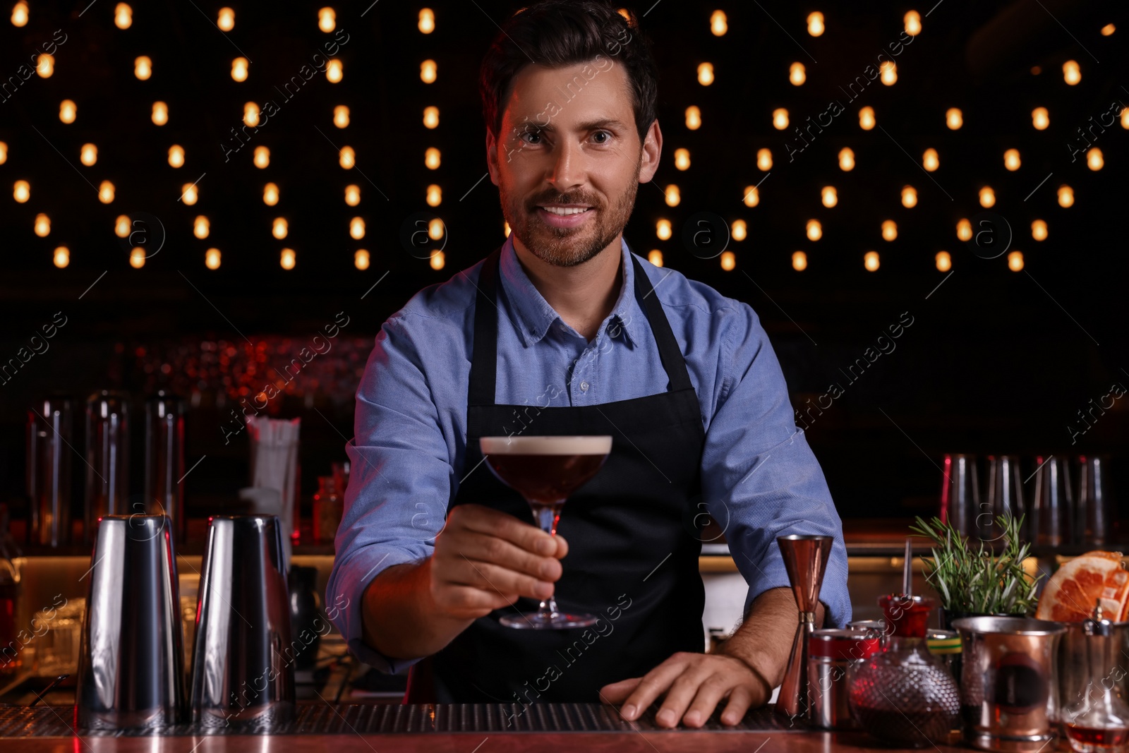 Photo of Bartender with Espresso Martini in bar. Alcohol cocktail