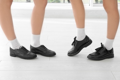 Photo of Girls in stylish school uniform indoors, focus on legs