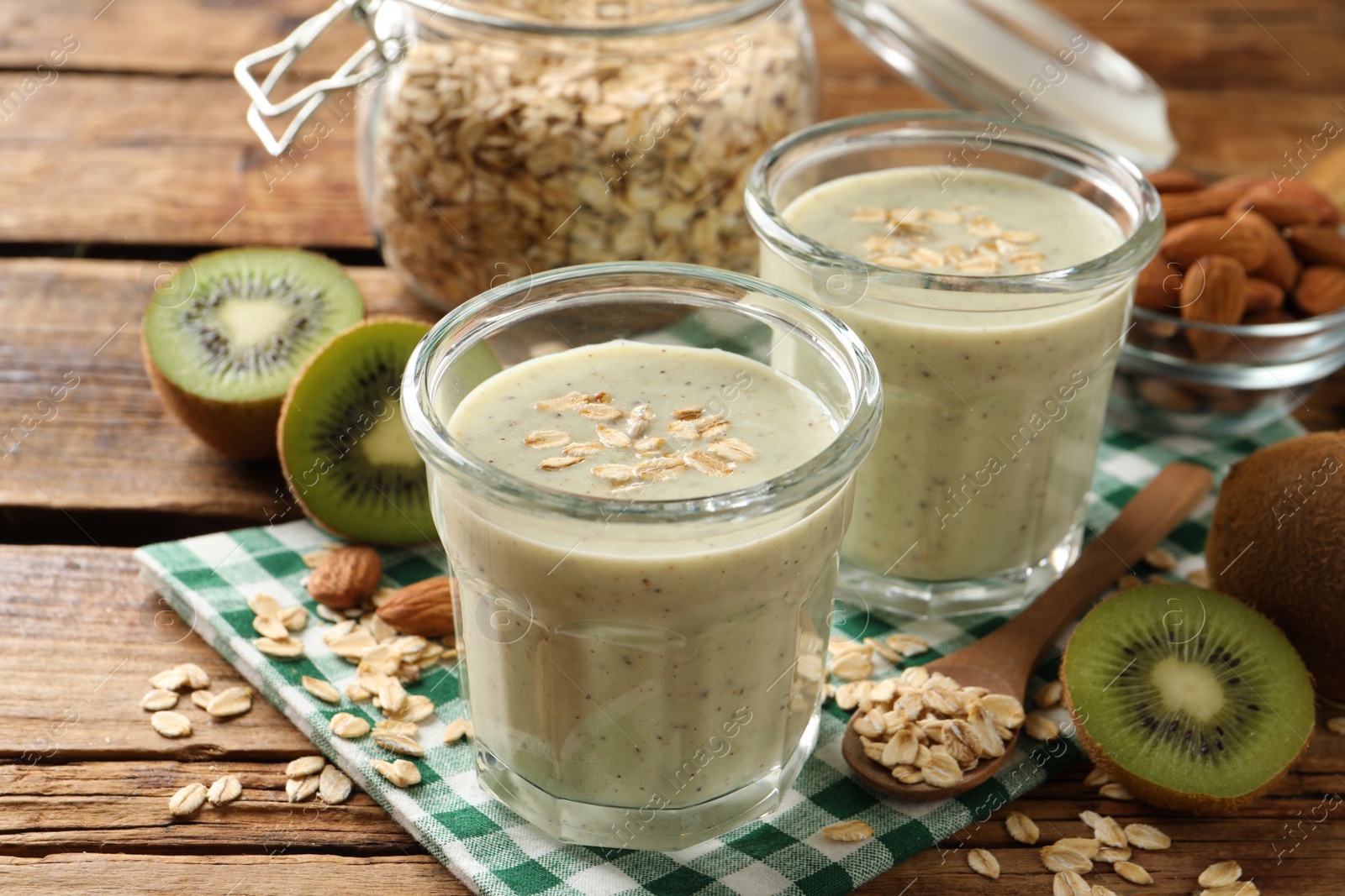 Photo of Tasty kiwi smoothie with oatmeal on wooden table