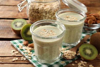 Photo of Tasty kiwi smoothie with oatmeal on wooden table