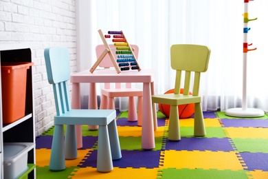 Stylish playroom interior with toys and modern furniture