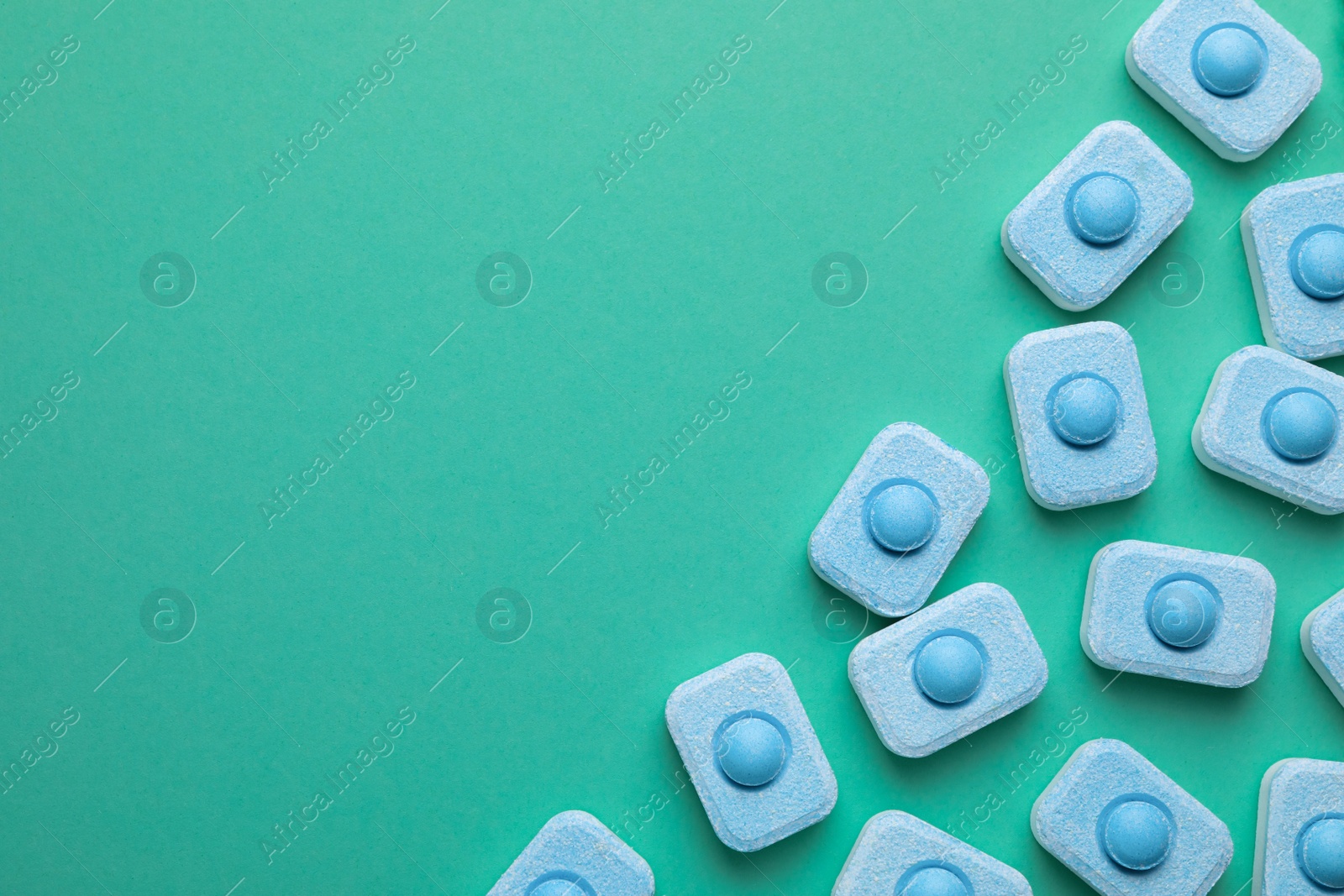 Photo of Water softener tablets on turquoise background, flat lay. Space for text