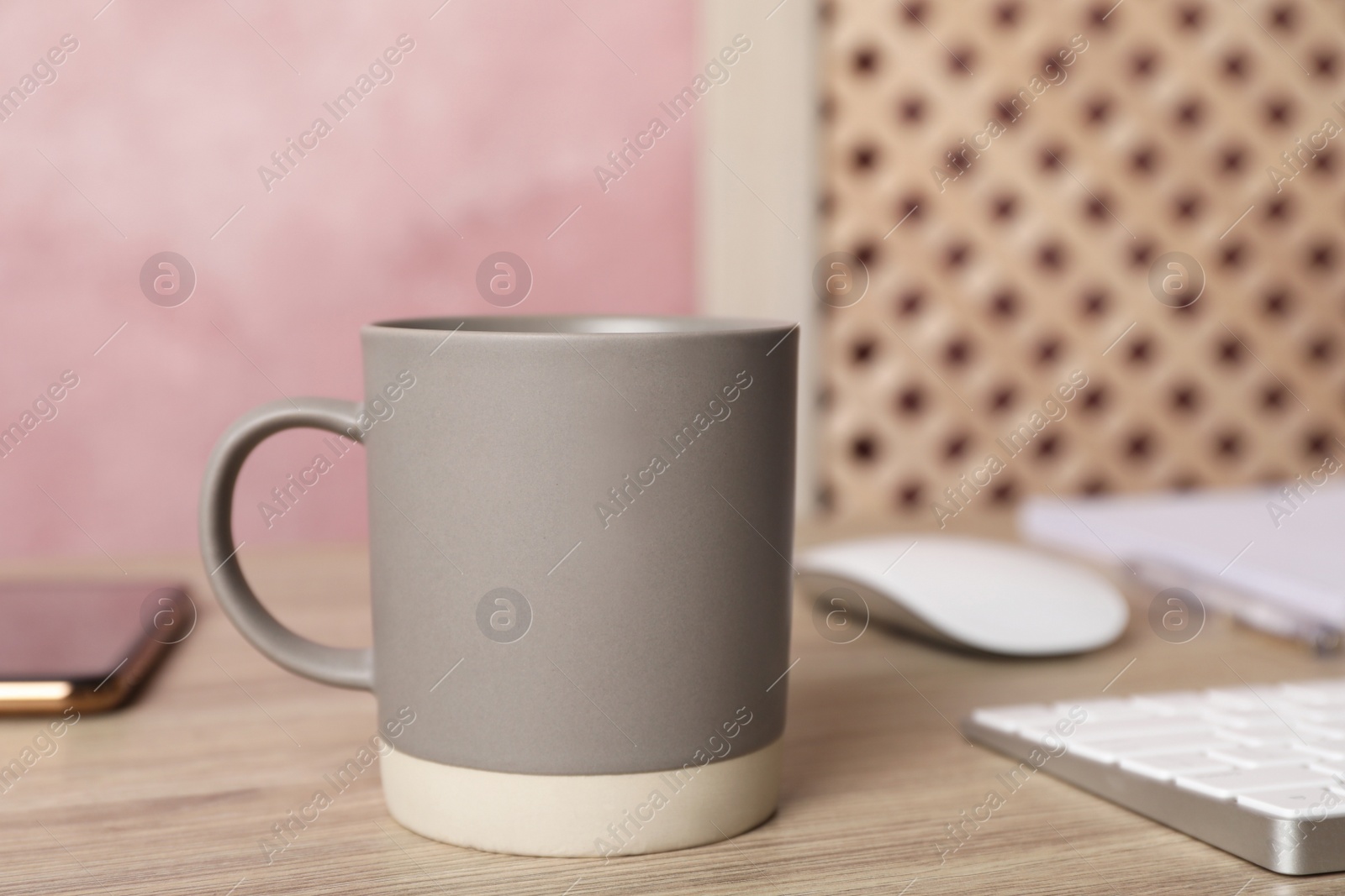 Photo of Coffee Break at workplace. Cup of hot drink on wooden table