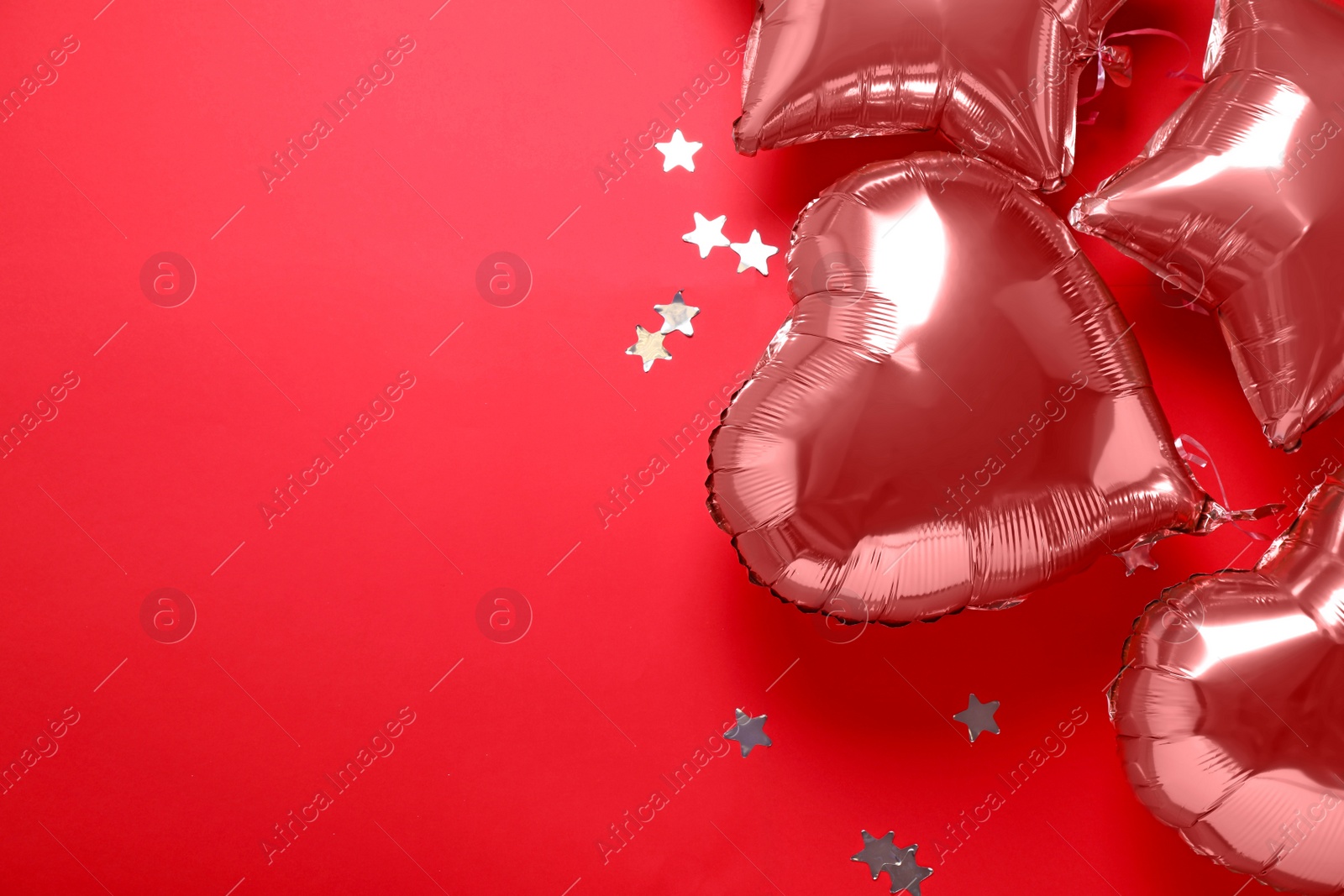 Photo of Colorful balloons and confetti on red background, flat lay. Space for text