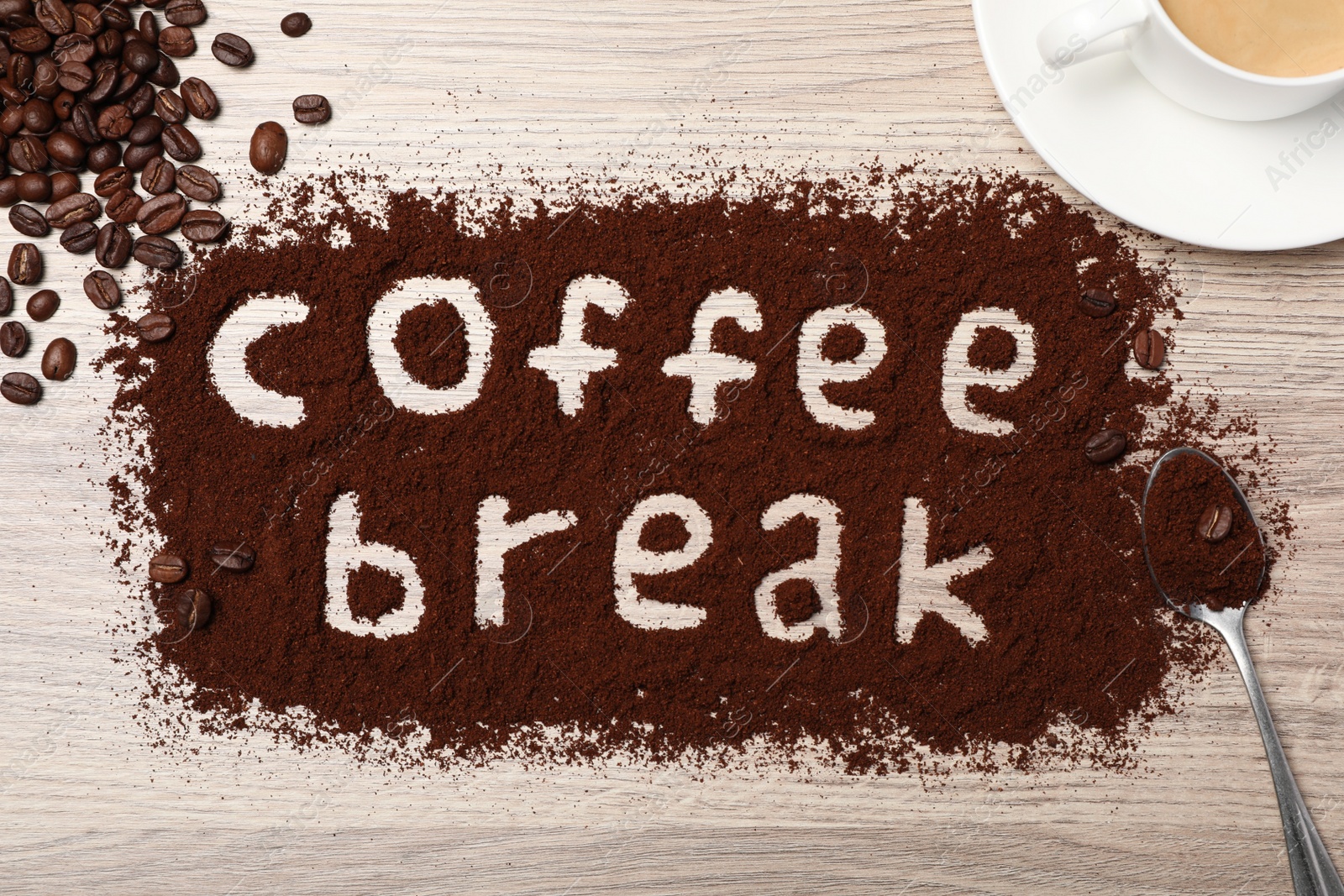 Photo of Phrase Coffee Break written in powder on wooden table, flat lay