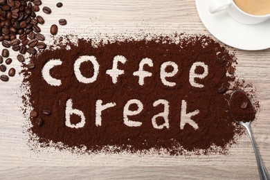 Photo of Phrase Coffee Break written in powder on wooden table, flat lay