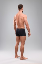 Photo of Muscular man on light grey background, back view. Sexy body