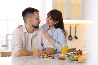 Photo of Happy couple spending time together during breakfast at home