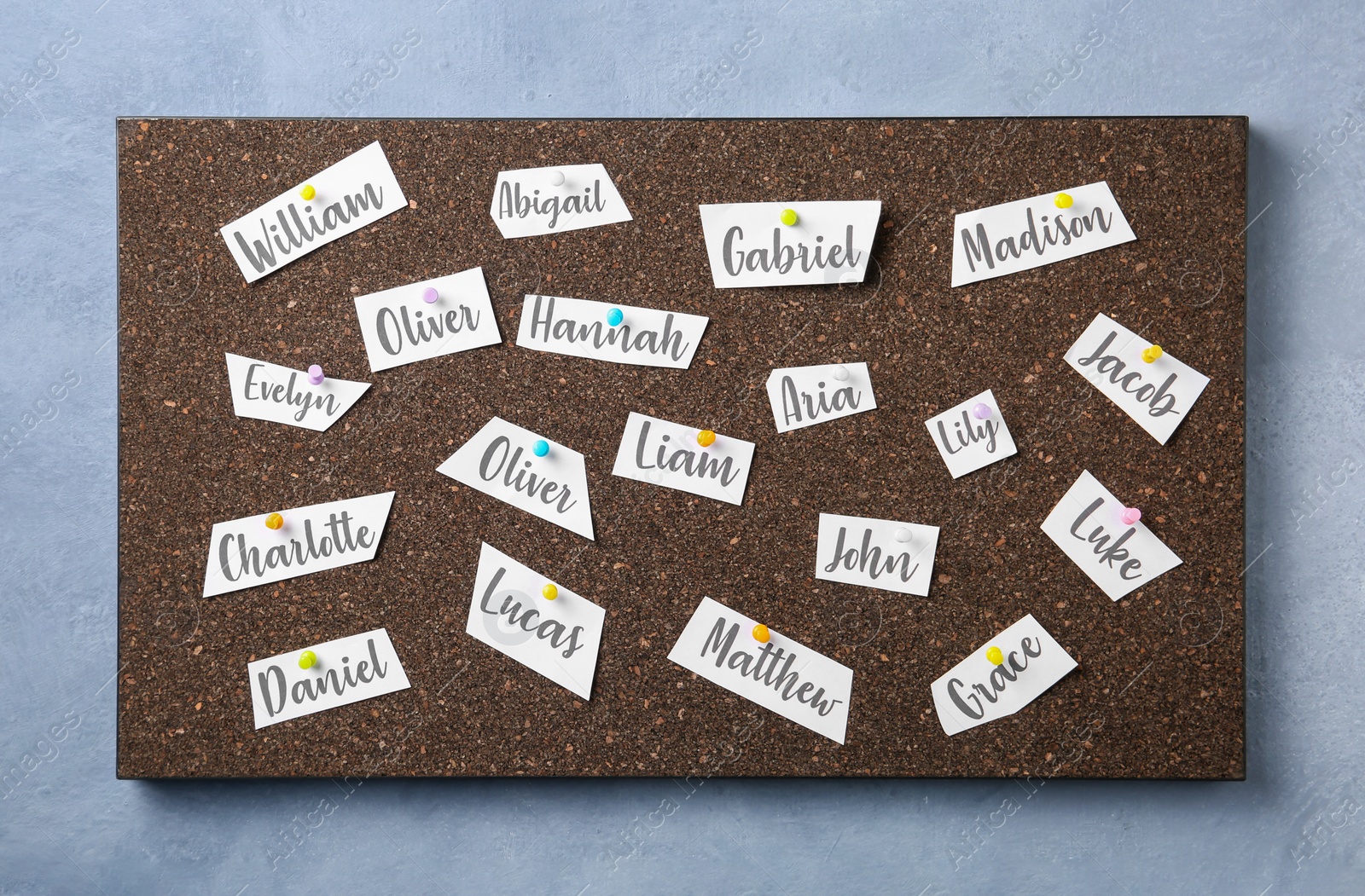 Photo of Cork board with baby names hanging on grey wall