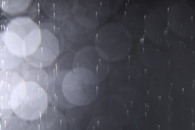 Photo of Rain drops falling down against dark background