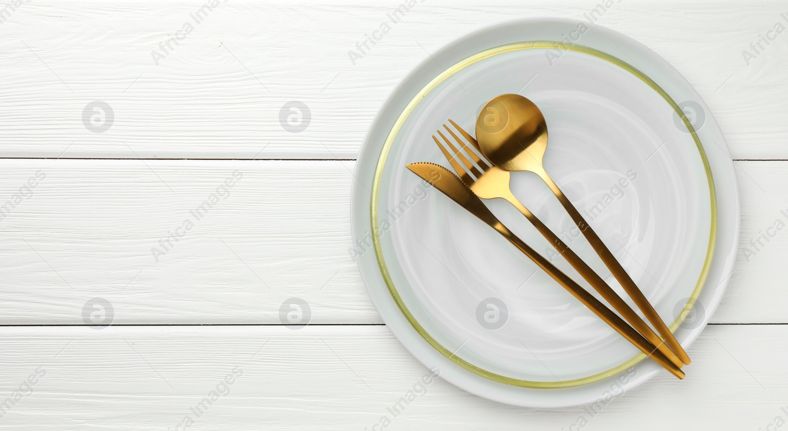 Photo of Stylish setting with cutlery and plate on white wooden table, top view. Space for text