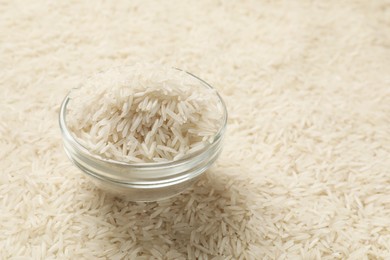 Photo of Bowl on raw basmati rice, closeup view. Space for text