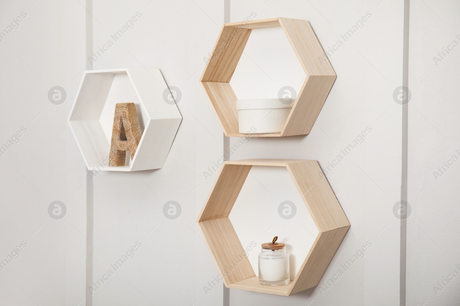 Photo of Honeycomb shaped shelves with decorative elements on white wall