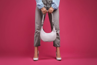 Photo of Fashionable woman with stylish bag on pink background, closeup