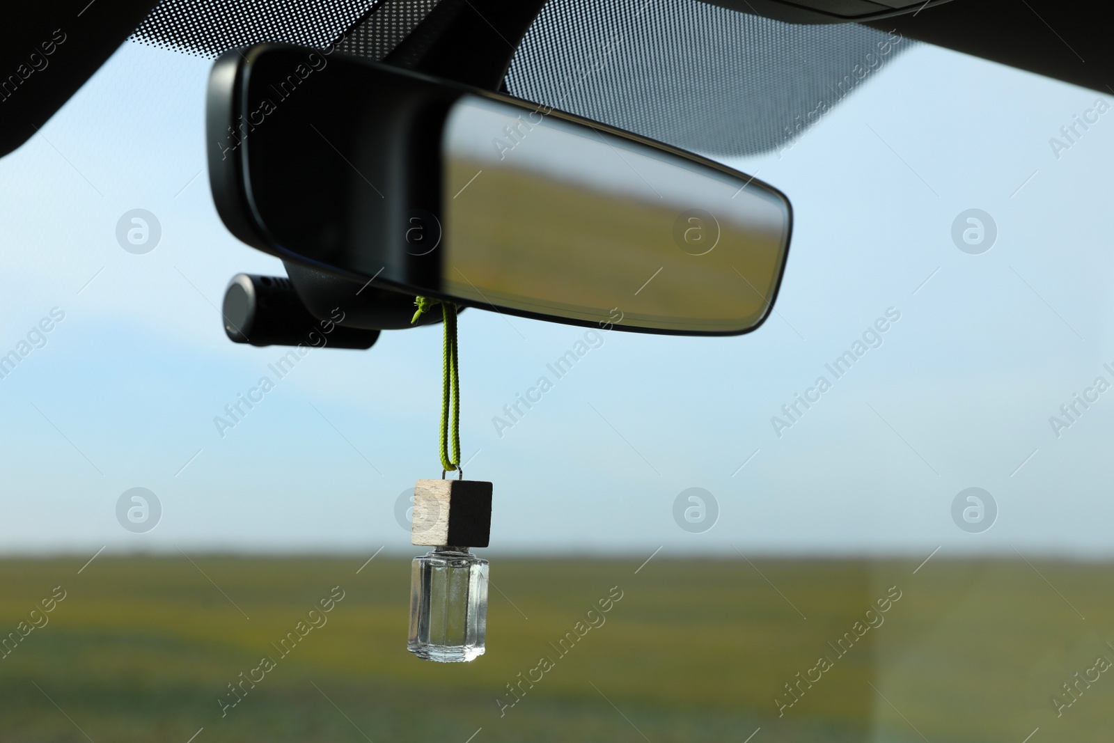 Photo of Air freshener hanging on rear view mirror in car