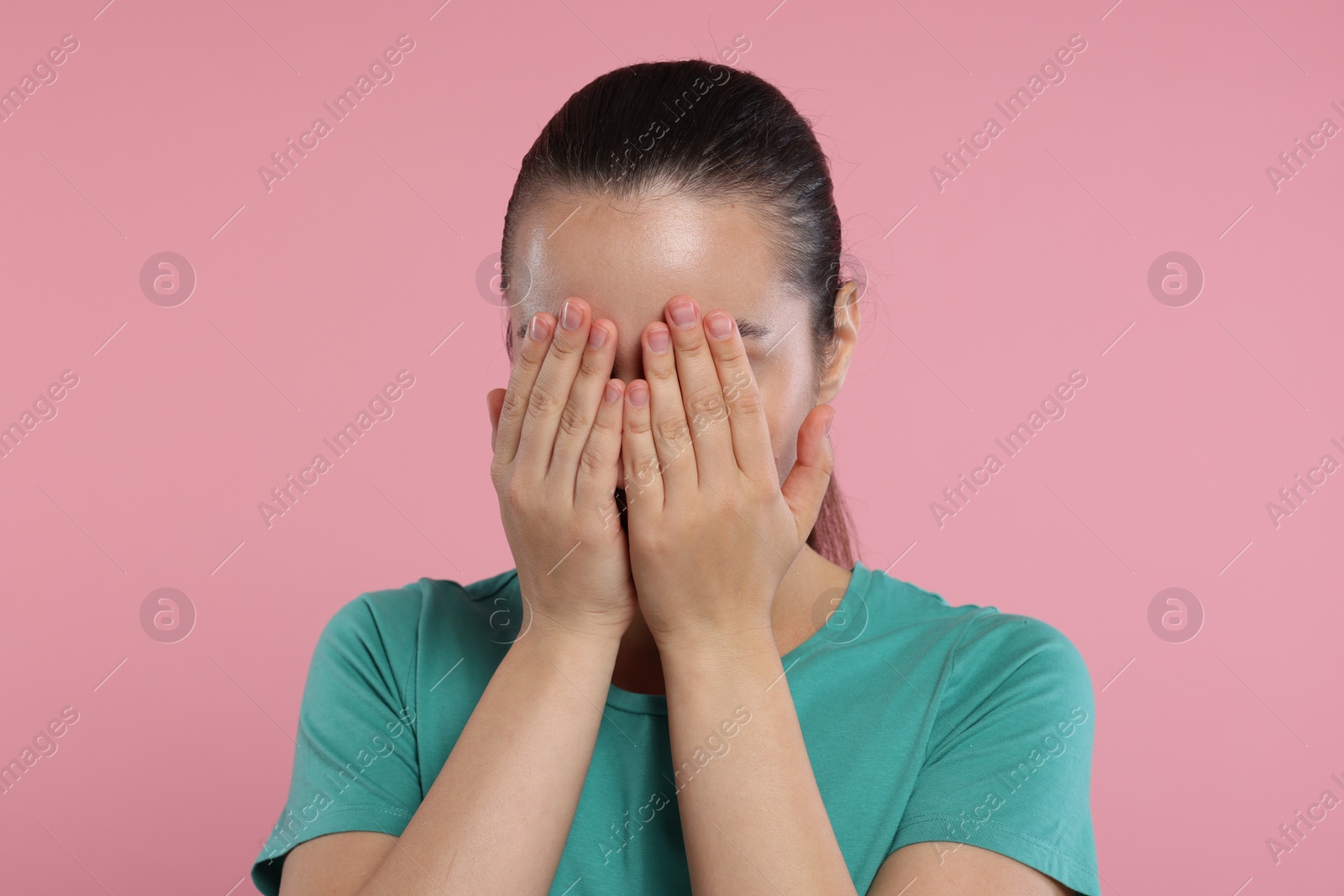 Photo of Resentful woman covering face with hands on pink background