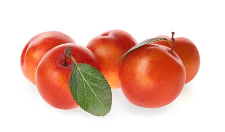 Delicious ripe plums with leaves isolated on white