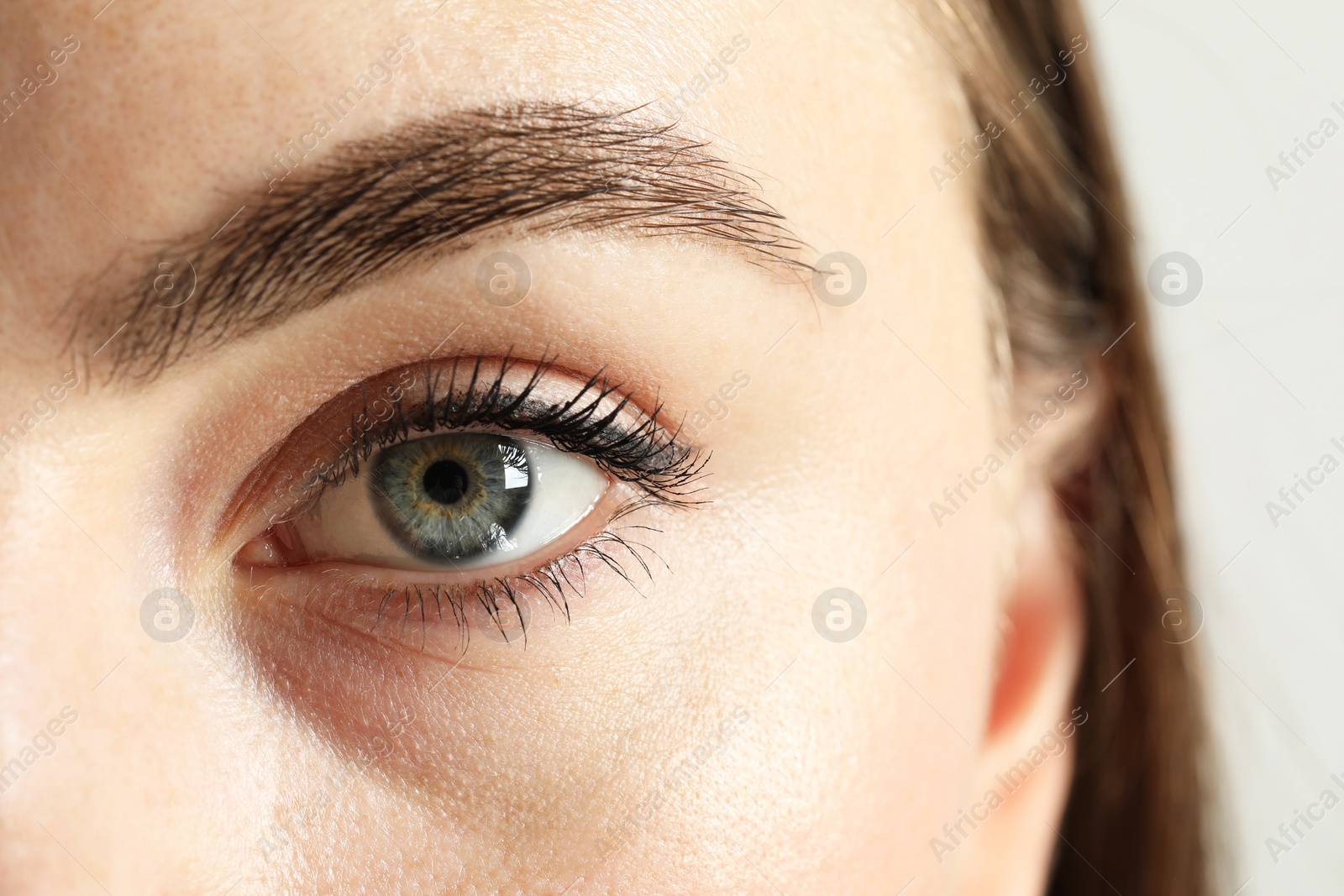 Photo of Macro photo of woman with beautiful eyes on light background