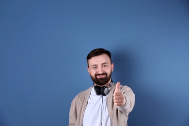 Photo of Portrait of handsome bearded man with headphones on color background