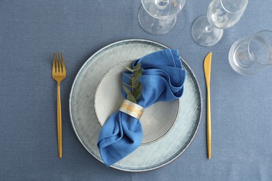 Photo of Stylish setting with cutlery, dishes, napkin, glasses and floral decor on table, flat lay