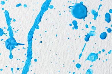 Blue paint splashes on white canvas as background. Art and creativity