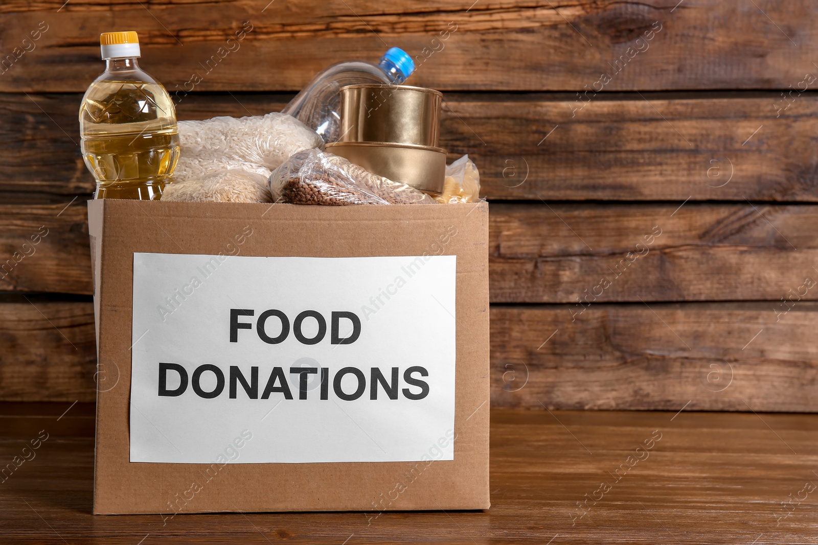 Photo of Donation box with food on wooden background