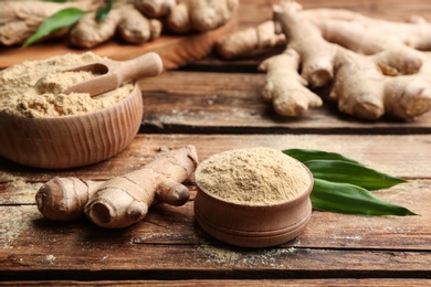 Photo of Dry ginger powder, fresh root and leaves on wooden table