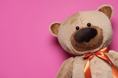 Photo of Cute teddy bear on pink background, top view. Space for text