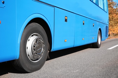 Modern blue bus on road, focus on wheel. Passenger transportation