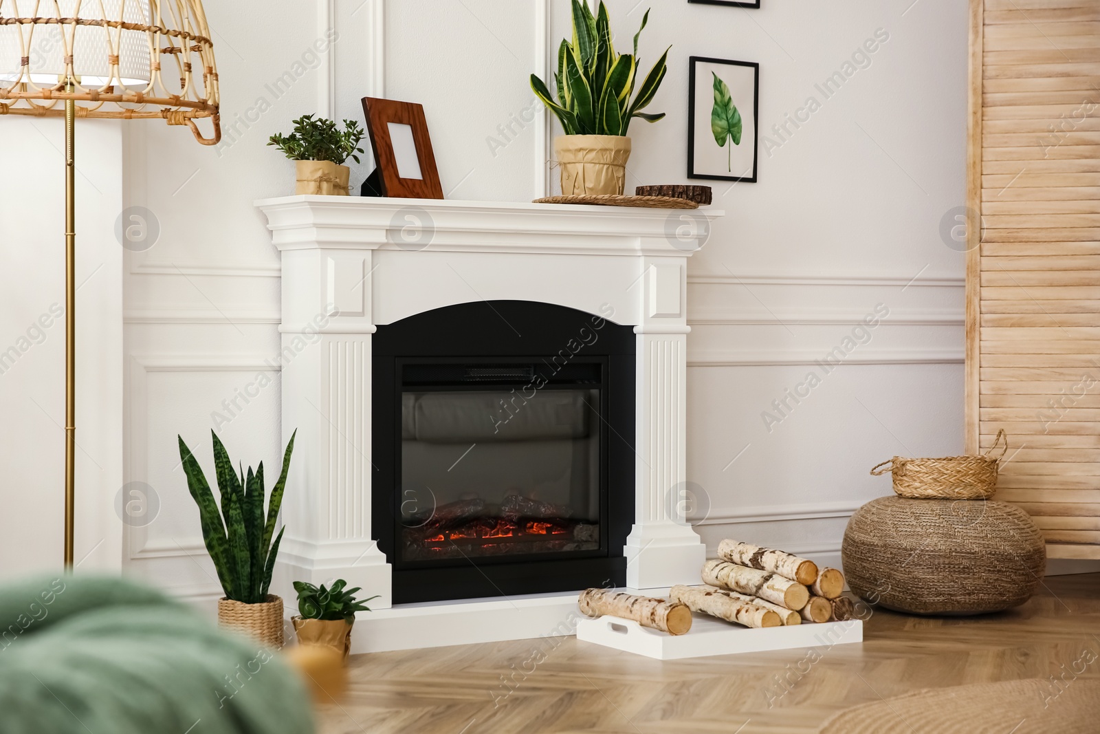 Photo of Elegant artificial fireplace in room. Interior design