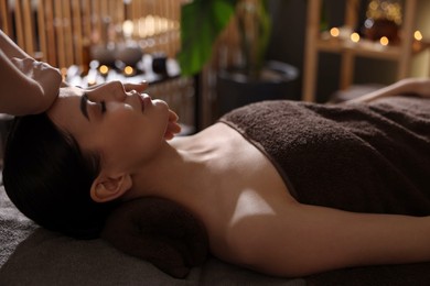 Spa therapy. Beautiful young woman lying on table during massage in salon