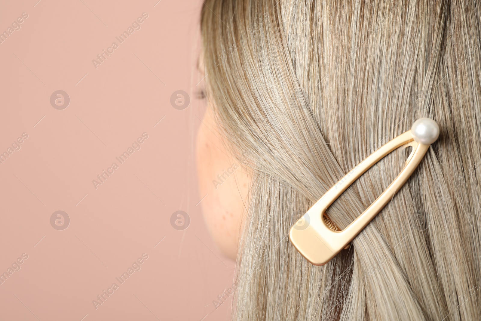 Photo of Young woman with beautiful hair clip on pink background, closeup