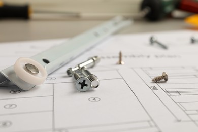 Photo of Drawer slide, plan and different fasteners on table, closeup. Furniture assembly