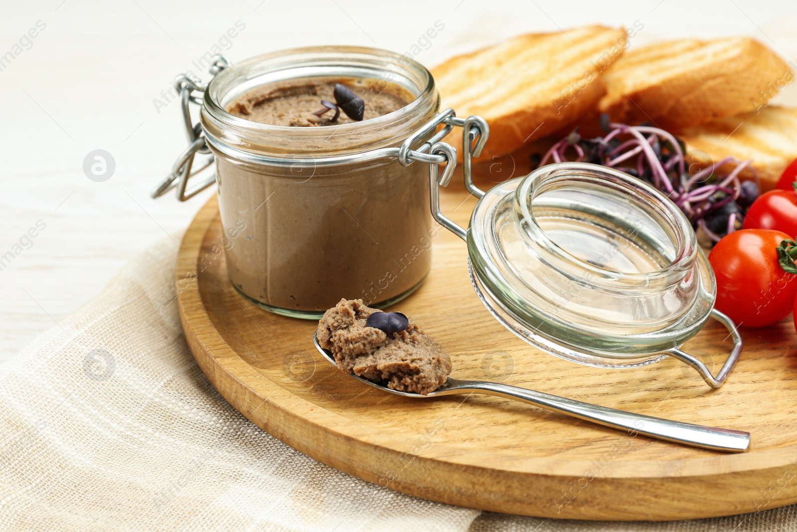 Photo of Delicious liver pate on wooden board, closeup view