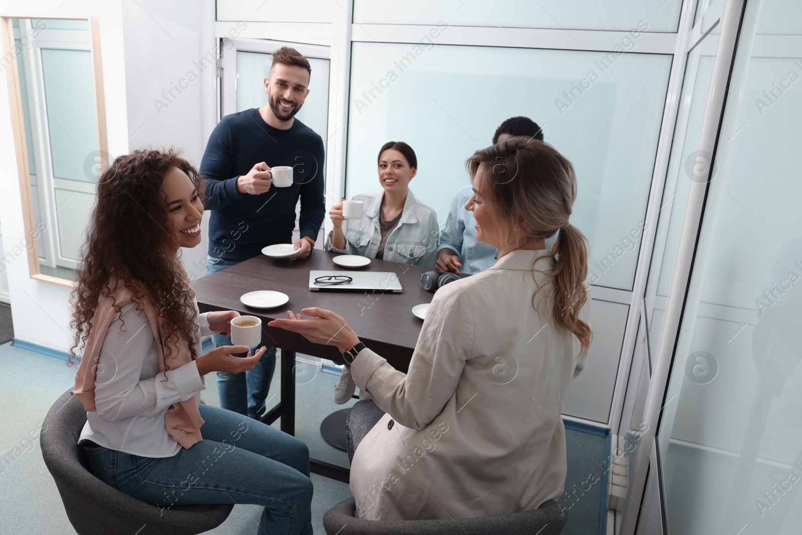 Photo of Team of employees enjoying coffee break together in office. Startup project