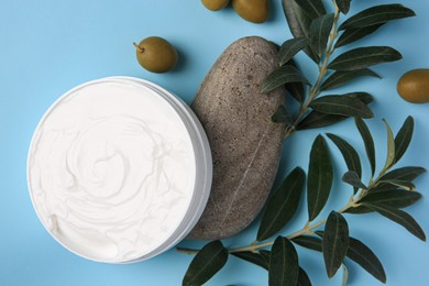Photo of Flat lay composition with jar of cream and olives on light blue background