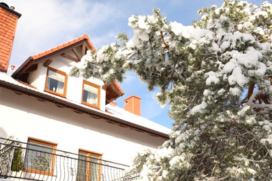Photo of Wooden house with balcony near tree in winter morning