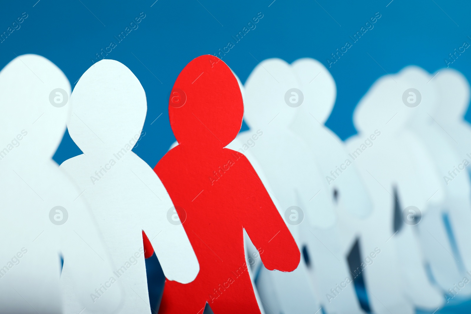 Photo of Paper people and different one on color background