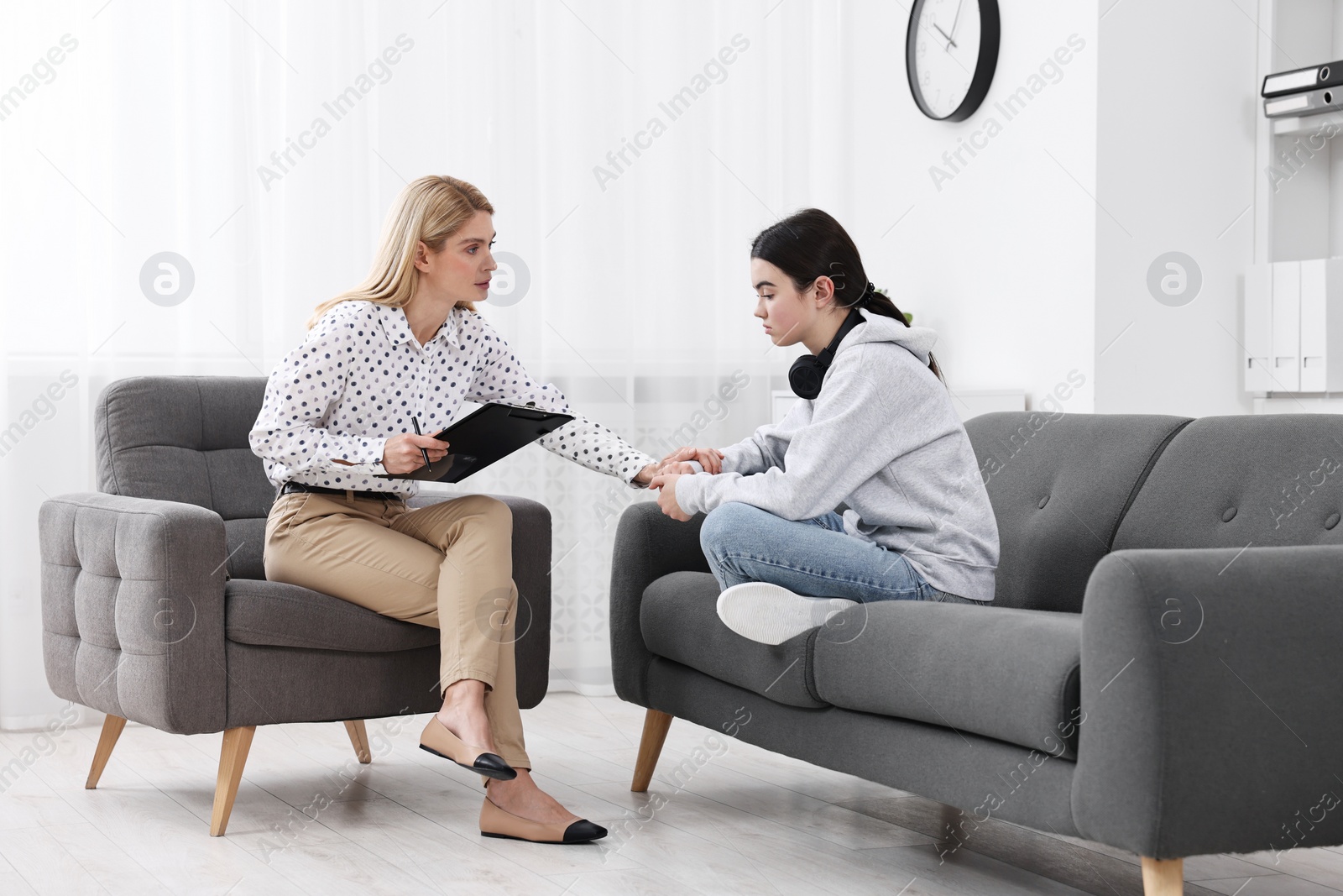 Photo of Psychologist working with teenage girl in office