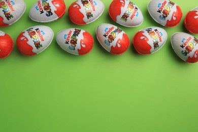 Photo of Sveti Vlas, Bulgaria - June 26, 2023: Kinder Surprise Eggs on light green background, flat lay. Space for text