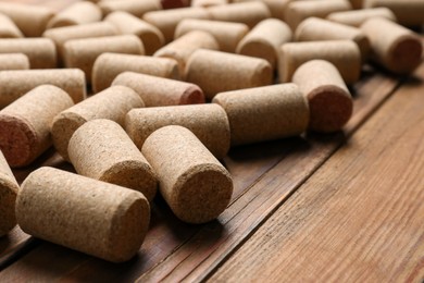 Photo of Many corks of wine bottles on wooden table, closeup