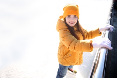 Cute little girl at outdoor ice skating rink